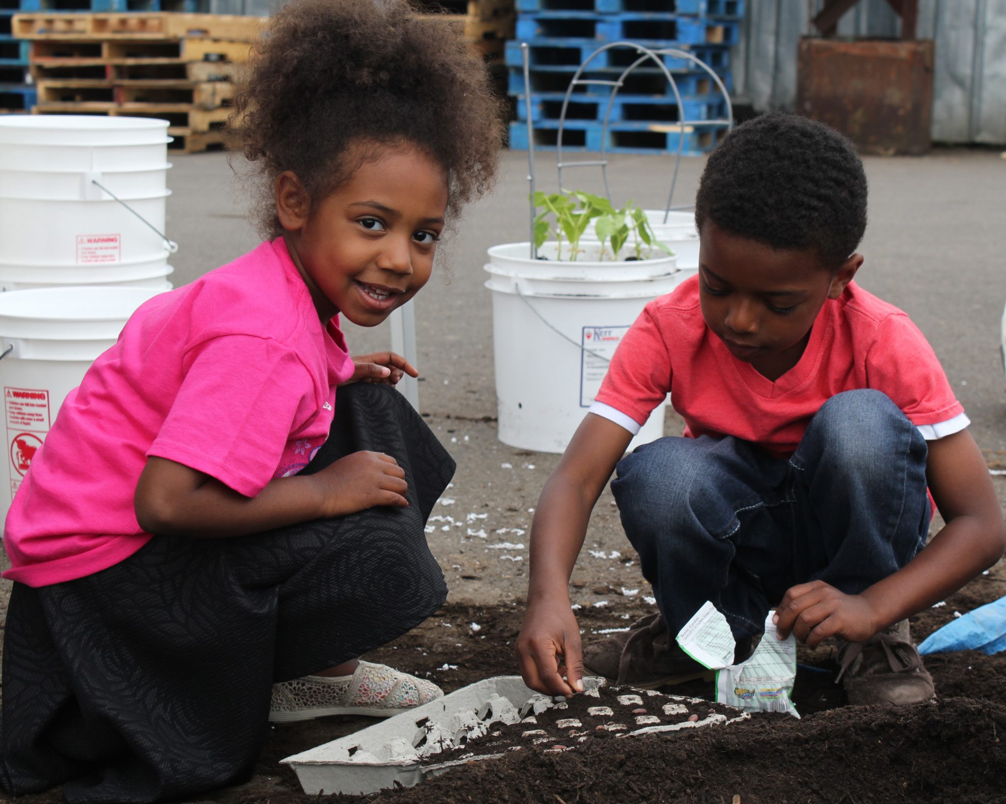 Nylinn and Raili plant seeds at Marion Polk Food Share