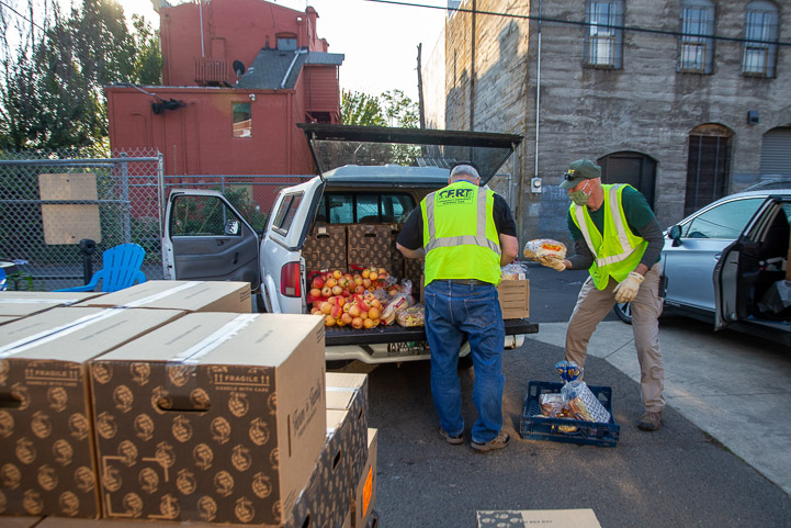 Volunteers load food in cars