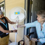 Meals on Wheels volunteer Kelly, left, delivers food and a fan to Judith in preparation for a heat wave that could bring record temperatures to the Salem area.