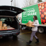 Julie loads her vehicle while volunteering as a driver for a new Food Share program providing home grocery delivery.
