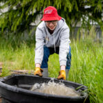Martin moves a tub full of liquid fish fertilizer at the Marion Polk Food Share Youth Farm.