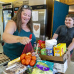 Stacy W. and her son Graeson shop for food at the Mill City/Gates Community Assistance Center. Before it was destroyed by wildfires in 2020, a family farm provided ample food for Stacy and her family.