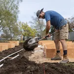 Reuben prepares to install above-ground beds at Santana Village Park Garden.