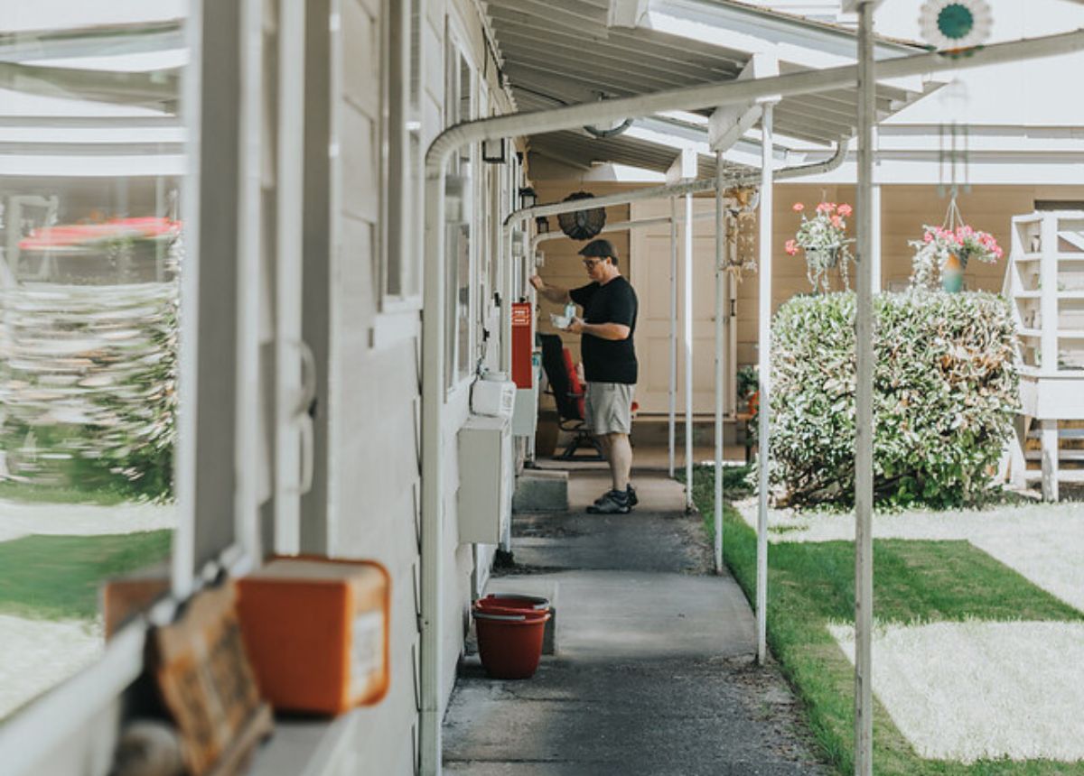 a meals on wheels volunteer driver knocking on someone's door making a delivery